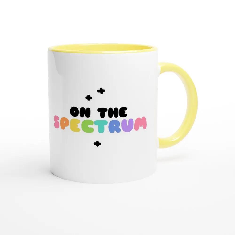 a white and yellow coffee mug with the words on the specctrum