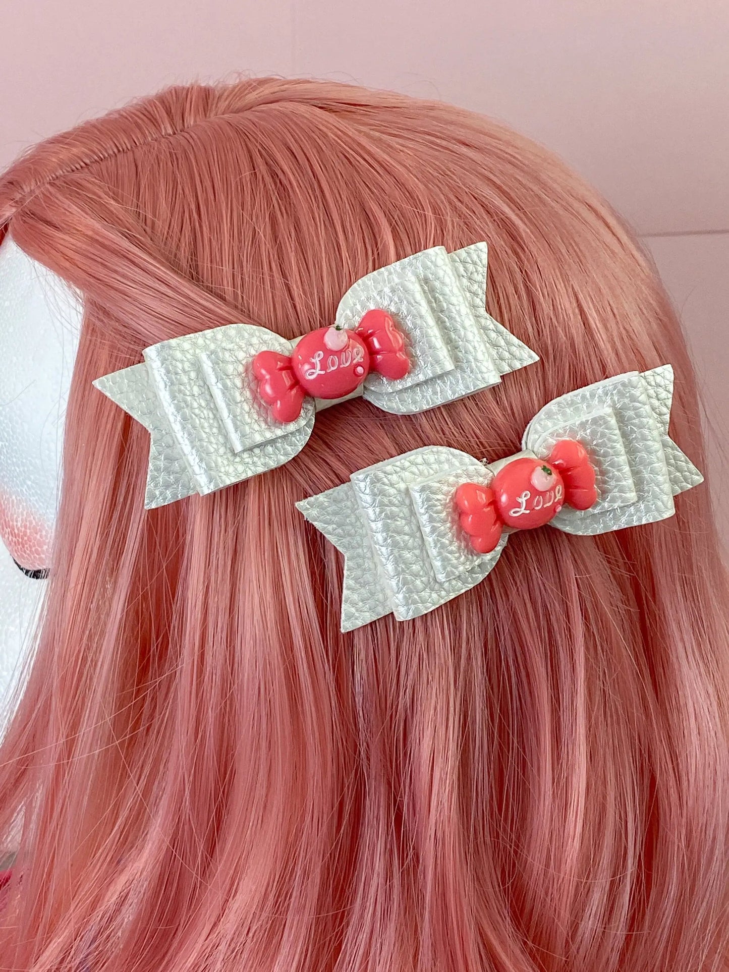 a close up of a person with pink hair and two bows