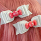 a close up of a person with pink hair and two bows