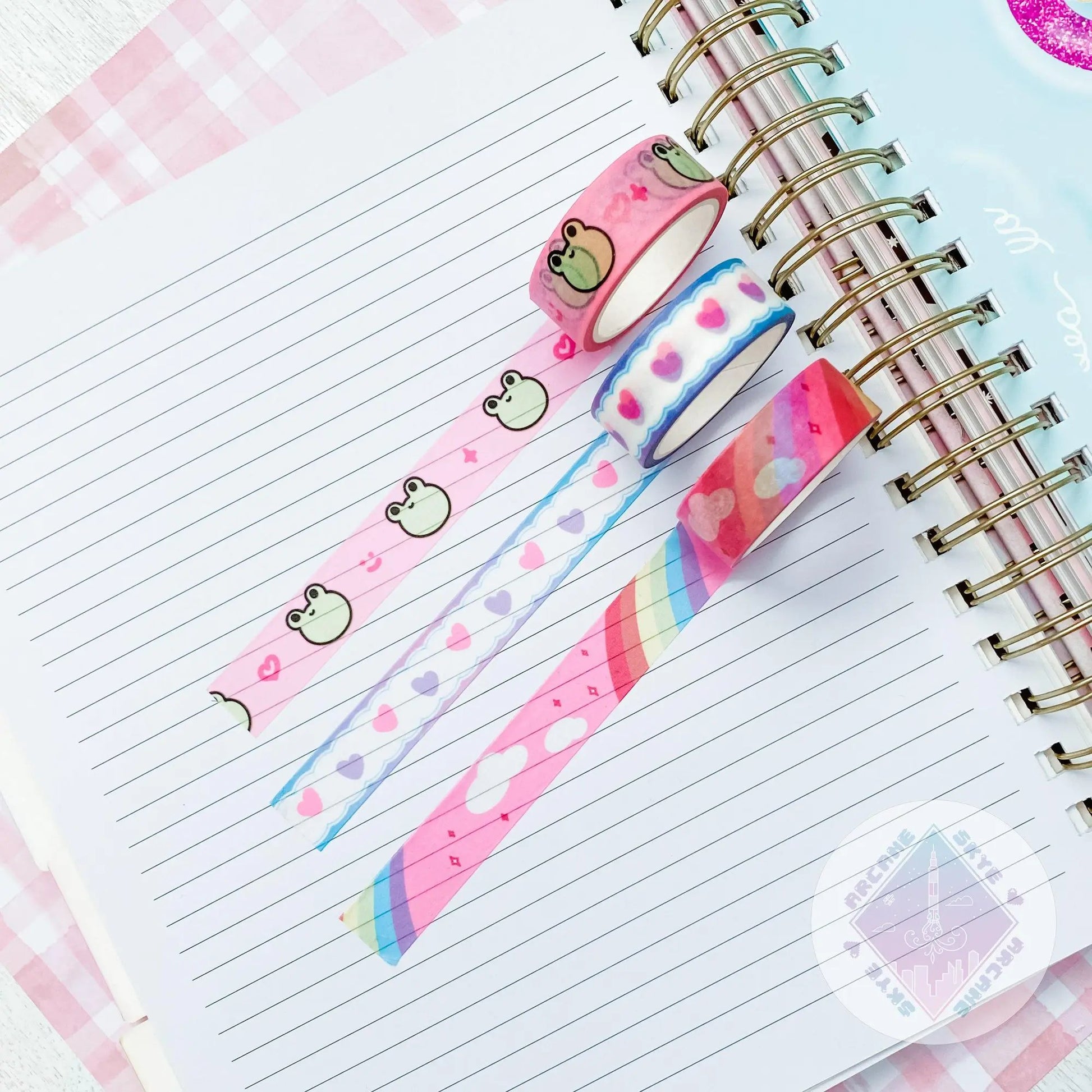 a spiral notebook with washi tape on top of it