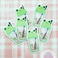 four stickers of a frog holding a toothbrush