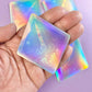 a hand holding a pair of holographic playing cards