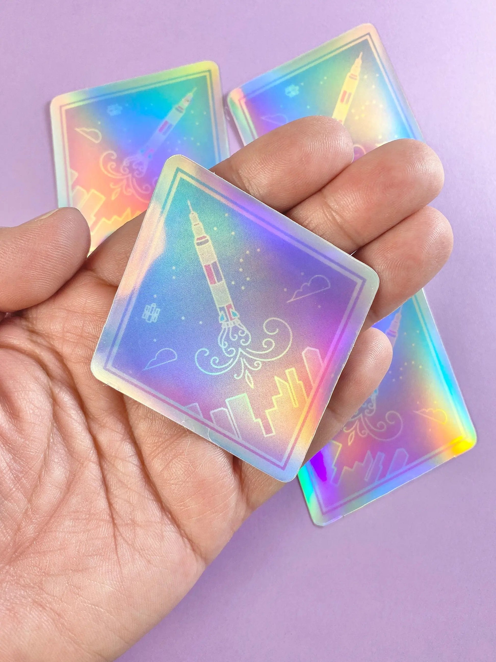 a hand holding a pair of holographic playing cards