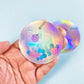 a hand holding two holographic discs with flowers on them