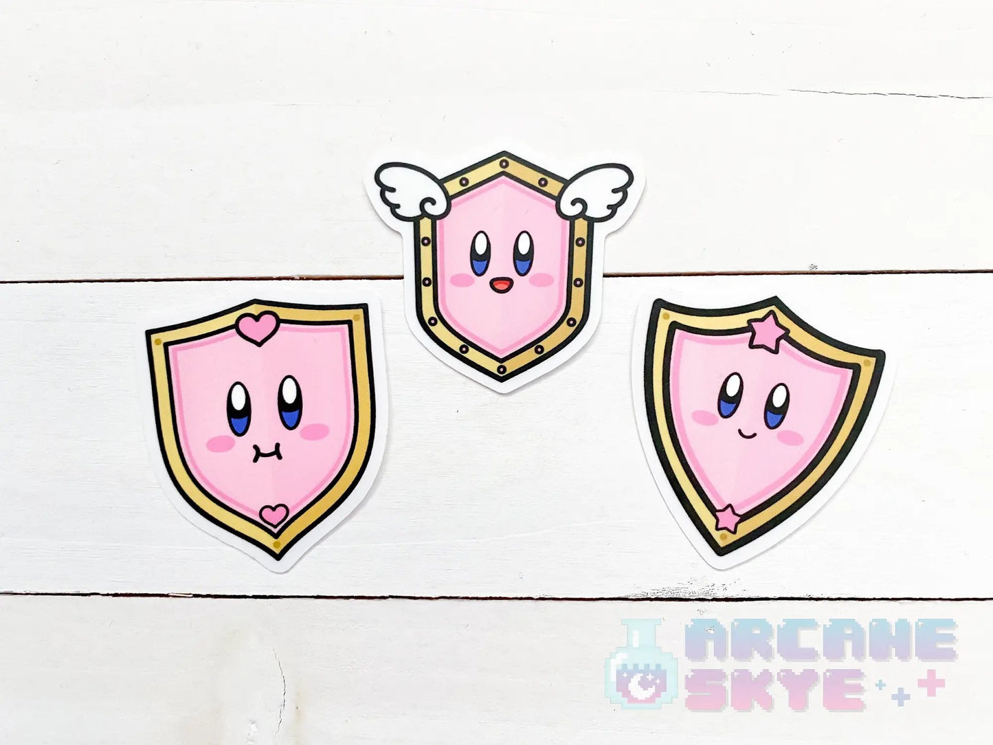 three pink stickers with angel wings on them